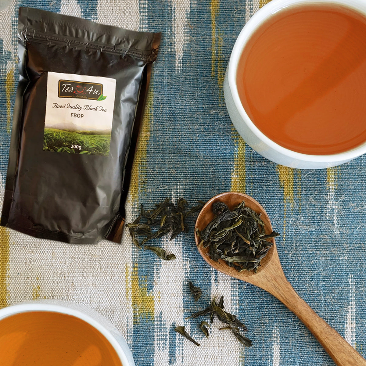 A cup of brewed FBOP Loose Black 7 oz Ceylon Tea next to a wooden spoon